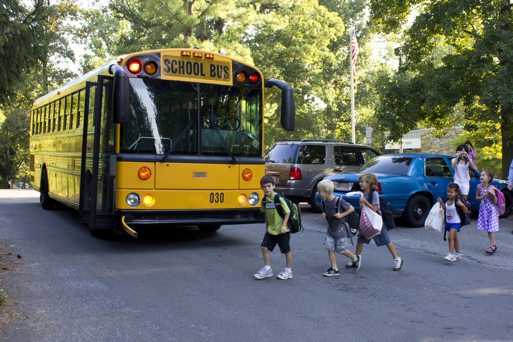 A group of second graders getting on a school bus for the first day of school